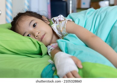 Close Up Beautiful And Adorable Face Of 5 Years Old Kid Asian Girl Who Is Sick Due To Virus Infection And Receive Medication In Hospital Shows Upset And Worry For Her Disease Alone On Her Bed.