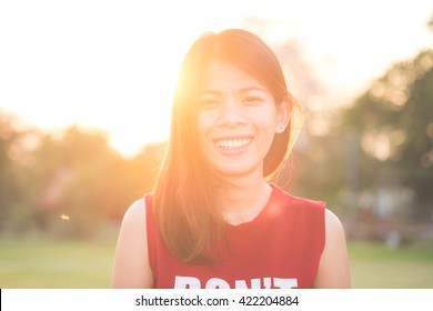 Nahaufnahme eines schönen asiatischen Mädchens mit einem Lächeln bei Sonnenuntergang.