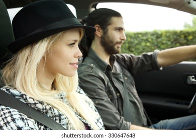 close up of a beautiful blond hipster girl with hat in car with boyfriend