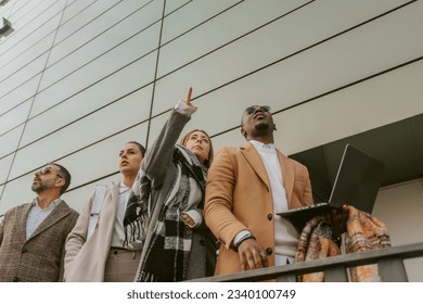 Close up of beautiful business woman pointing up while standing with her colleagues - Powered by Shutterstock