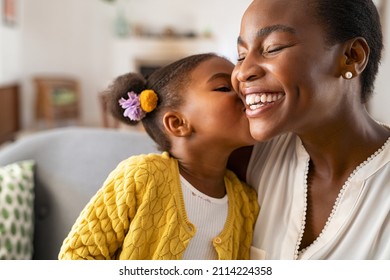 Close up beautiful daughter kissing mother cheek at home  African little girl giving kiss to happy mother  Lovely black female child kissing cheerful   proud woman cheek for mother's day 