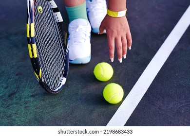 Close Up Of Beautiful Fashion Teen Girl Picking Up Tennis Ball At Court, Playing And Training Her Tennis Skills. Summer Camp, Sport Club And Youth Active Authentic Life Background