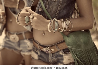 close up of beautiful hippie girls in denim clothes and boho accessories