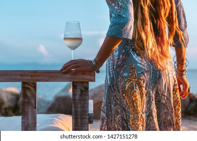 close up of beautiful l fashion model in elegant dress at sunset with glass of wine