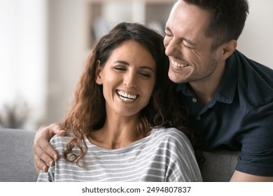 Close up beautiful overjoyed Latin couple talking, laughing, spend time together at home. Cheerful husband hugs his beloved beautiful wife, joking, giggling, feel carefree and happy. Relations, love - Powered by Shutterstock