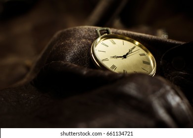 Close Up Of A Beautiful Pocket Watch. Luxury Men's Watch Placed On A Leather Background. Fashionable Brown Leather Bag With A Watch On Top Of It.