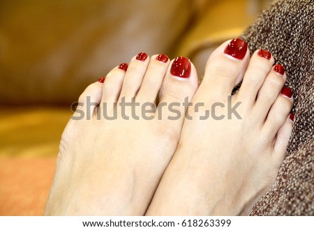 Close up beautiful red toes of woman feet. Red toes female. Nail polished.