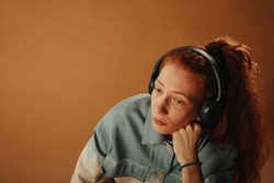 Close Up Of Beautiful Sad Ginger Girl Listening Music While Sitting At The Studio