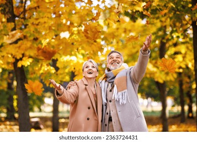 Close up of beautiful smiling senior family couple husband and wife  with tenderness enjoy the leaf fall while in park on autumn day, retired man and woman embracing enjoying walk  - Powered by Shutterstock