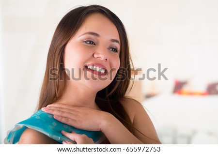Close up of a beautiful smiling woman holding ice gel pack on her shoulder, medical concept, in office background