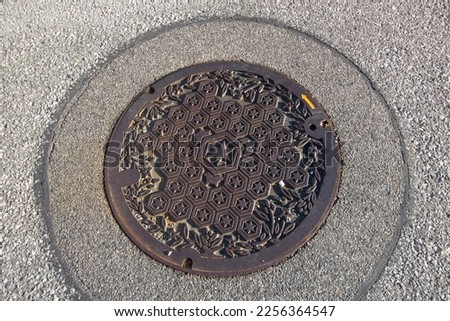 Close up of a beautiful stars pattern metal manhole cover on the ground, Hikone, Shiga, Japan