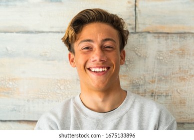 Close Up Of Beautiful Teenager Smiling And Laughing Alone At Home - Portrait Of Face Of Young Man