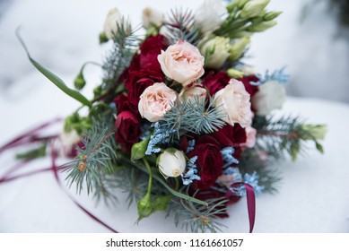 Close Up Of Beautiful Wedding Bouquet With Colorful Flowers, Pink And Red Roses On Snow. Long Ribbons Around. Winter Wedding And Season Floral Concept. 