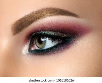 Close Up Of Beautiful Woman Eye With Multicolored Smokey Eyes Makeup. Modern Fashion Make Up. Studio Shot