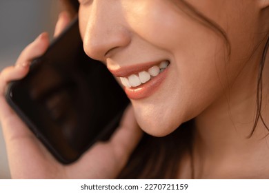 Close up of beautiful woman mouth and teeth talking on mobile phone happiness with positive emotional. Beautiful lips smile nice and gentle. - Shutterstock ID 2270721159