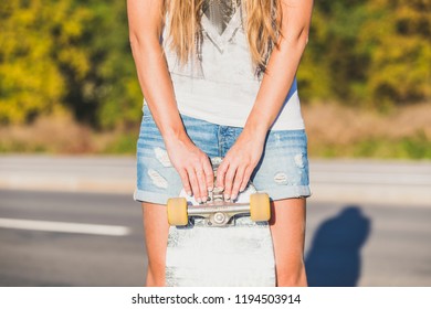 Close Up Of Beautiful Young Woman Holding Skateboard Deck In Front Of Her