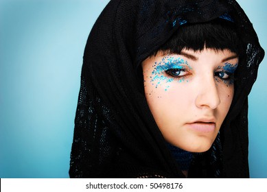 A Close Up Of A Beautiful Young Woman Wearing Sparkly Make Up And A Head Scarf.