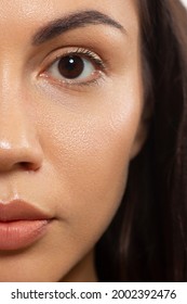 Close Up Beauty Of A Half Face Of A Woman With Wet Radiant Skin And Big Gray Eyes. Fashionable Natural Makeup And Wet Facial Hair. Pink Lipstick With Kissed Lips