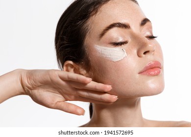 Close Up Of Beauty Natural Woman With Freckles, Clean And Fresh Skin Tone, Close Eyes, Apply Facial Skincare Cream With Anti-aging Detoxifying Effect, Moisture And Noirish Skin, White Background.