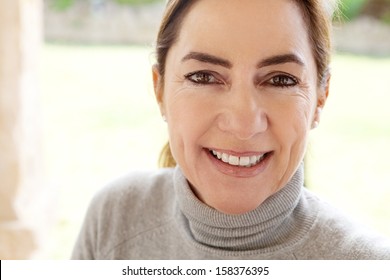 Close Up Beauty Portrait Of An Attractive Joyful And Positive Mature Hispanic Woman By A Green Grass Garden During A Sunny Day At Home, Smiling And Feeling Positive.