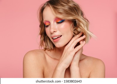 Close up beauty portrait of an attractive smiling young blonde topless woman with bright makeup standing isolated over pink background, posing - Shutterstock ID 1583802643