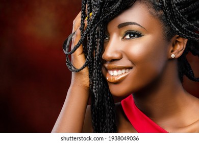 Nahaufnahme Schönheitsportrait von jungen attraktiven Afro-Amerikanerin mit charmantem Lächeln. Mädchen mit Hand in Brauntönen auf dunkelrotem Hintergrund.