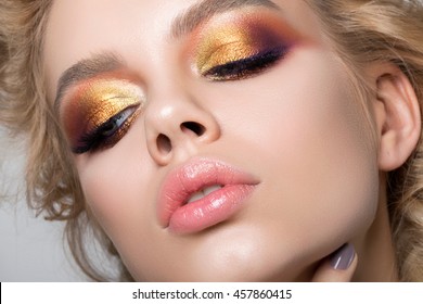 Close up beauty portrait of young woman with beautiful summer bright makeup. Modern smokey eyes with colorful metallic eyeshadows. Studio shot