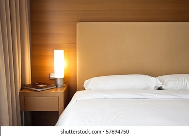 Close Up Of A Bed With White Sheets And A Cozy Lamp