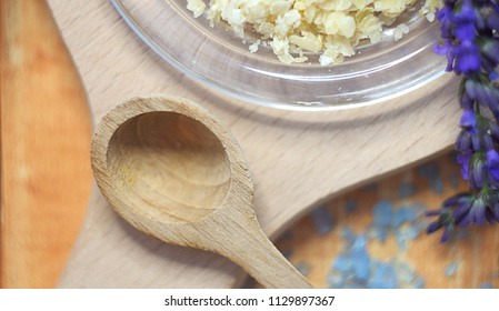 Close up of bee wax and lavender on a saucer with a wooden spoon - Shutterstock ID 1129897367