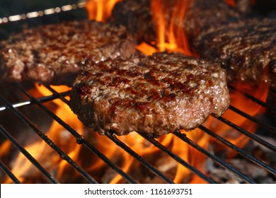 Close up beef or pork meat barbecue burgers for hamburger prepared grilled on bbq fire flame grill, high angle view - Shutterstock ID 1161693751
