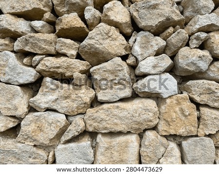 close up of beige limestone wall with rough natural stone blocks irregular texture pattern rustic masonry surface background