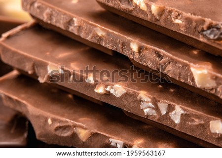 Close up of Belgian milk chocolate. Stack of milk and dark chocolate with nuts. Heap of chocolate bars. side view. Bitter chocolate on blurredbackground Stock photo © 