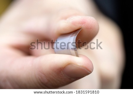 Close up of bendable bio metric chip reader in hand between two fingers