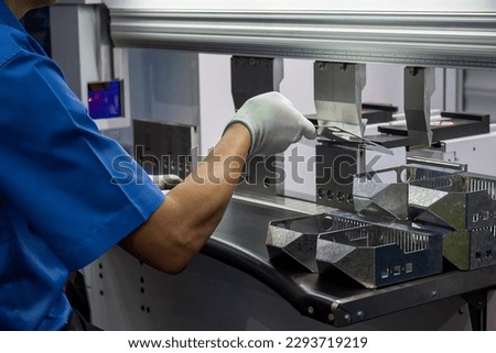 Close up the bending machine operator hold the sheet metal parts and  wear safety  glove. The sheet metal working operation by skill operator.