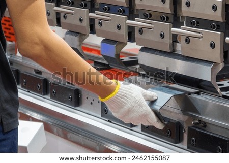 Close up the bending machine operator hold the sheet metal parts. The sheet metal working operation by skill operator.