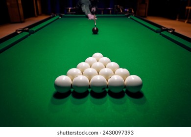Close billiard man player arm breaking the pyramid by striking the ball with cue stick