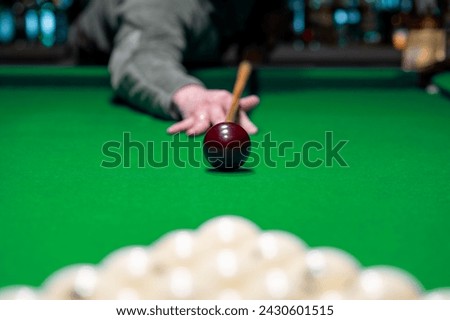 Close billiard man player arm breaking the pyramid by striking the ball with cue stick
