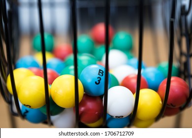 A Close Up Of A Bingo Cage Filled With Multi-colored Balls. Each Ball Has A Letter And Number On It That Corresponds To A Number On The Player's Bingo Card. Bingo Is A Game Of Chance.