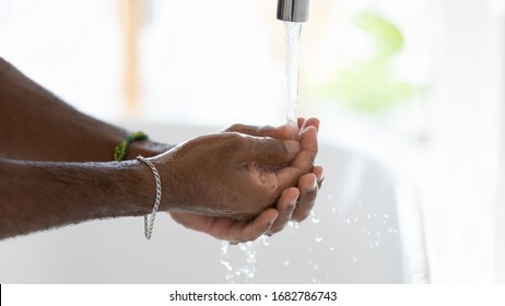 Close up of biracial man wash clean hands with antibacterial liquid tap water protect from corona virus pandemic, person take care of hygiene, stop covid-19 coronavirus epidemic, healthcare concept