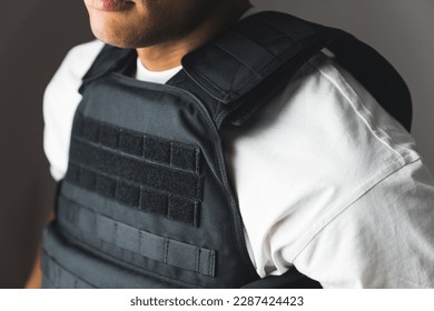 Close up of black bullet proof vest, body armor on man body. No face. High quality photo