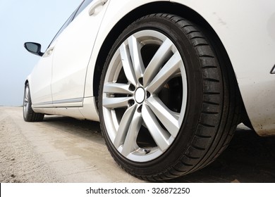 Close Up Of A Black Car Tyre Park On The Sand