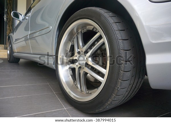 Close up of a black car tyre park at\
home. Sliver car with tyre                              \
