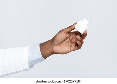 Close Up Of Black Doctor Hand Holding Box With Pills Over White Background