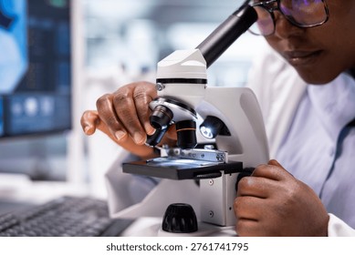 Close up of black expert analyzing samples in chemistry lab with microscope and observation tools. Scientist advancing genetics research, combining pathology analysis with biochemistry studies.