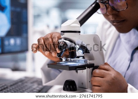 Close up of black expert analyzing samples in chemistry lab with microscope and observation tools. Scientist advancing genetics research, combining pathology analysis with biochemistry studies.