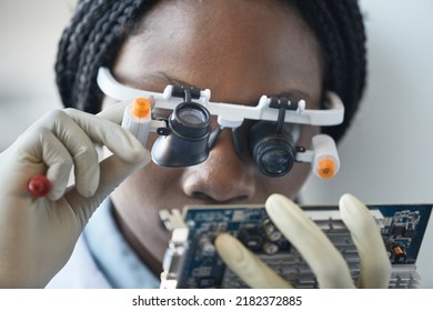 Close Up Of Black Female Scientist Wearing Magnifying Glasses And Inspecting Hardware Part In Engineering Lab