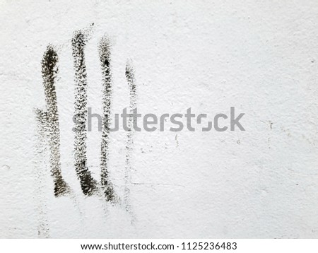 Close up of black fingerprints stained on the dirty grunge wall texture background.
