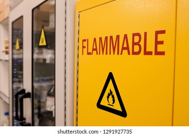 Close up black flammable sign with  
 red letter flammable on doors of 
 yellow flammable cabinet in laboratory room 
