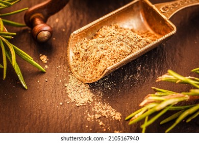 Close Up Of Black Ground Pepper In Metal Scoop, Spice Grinder, Green Rosemary Herb On Black Stone  Background , Macro