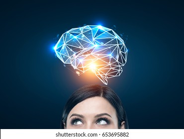 Close up of a black haired woman s head looking to the left and standing near a dark blue wall with a blue brain hologram shining with an orange light above her head